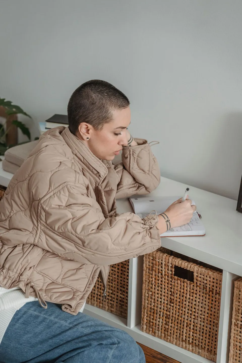 A woman taking time to write and reflect at a table.