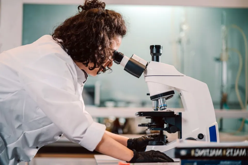 A laboratory scientist working with a microscope.